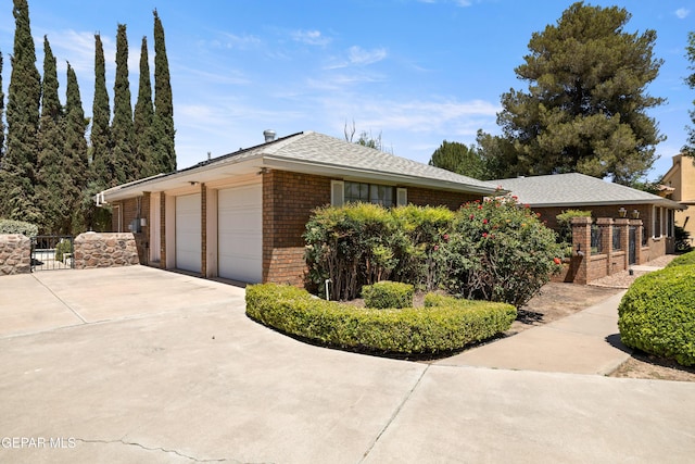 5445 Connors Ln, El Paso, TX 79932 - view of side of home featuring brick siding, a gate, concrete driveway, and an attached garage