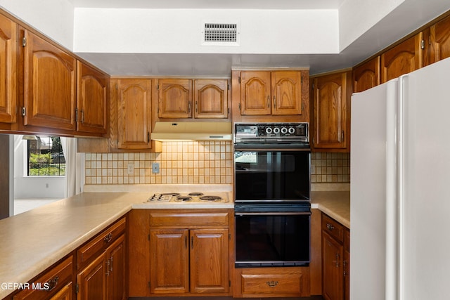5445 Connors Ln, El Paso, TX 79932 - kitchen with white appliances, light countertops, decorative backsplash, and brown cabinets