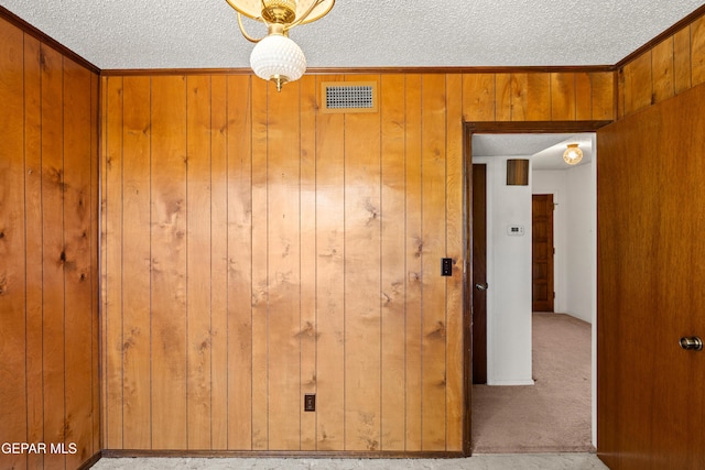 5445 Connors Ln, El Paso, TX 79932 - carpeted spare room with a textured ceiling, wooden walls, and crown molding
