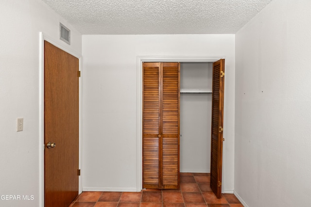 5445 Connors Ln, El Paso, TX 79932 - unfurnished bedroom with a closet, a textured ceiling, tile patterned flooring, and baseboards