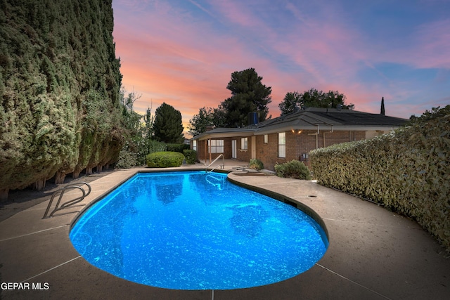 5445 Connors Ln, El Paso, TX 79932 - pool at dusk with a patio and an outdoor pool