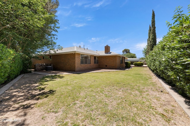 5445 Connors Ln, El Paso, TX 79932 - rear view of house with brick siding, a chimney, and a yard
