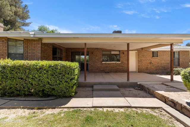 5445 Connors Ln, El Paso, TX 79932 - doorway to property with brick siding, a chimney, and a patio