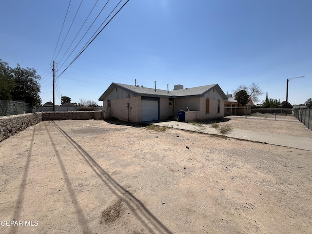 736 Jamestown Rd, El Paso, TX 79907 - rear view of property featuring brick siding, an attached garage, a fenced backyard, and dirt driveway