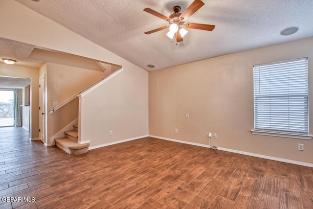 11924 Mesquite Rock Dr, El Paso, TX 79934 - empty room featuring a textured ceiling, ceiling fan, wood finished floors, stairway, and vaulted ceiling