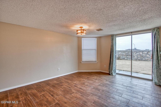 11924 Mesquite Rock Dr, El Paso, TX 79934 - unfurnished room featuring wood finished floors, baseboards, a textured ceiling, and floor to ceiling windows