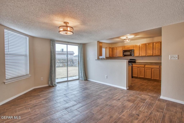 11924 Mesquite Rock Dr, El Paso, TX 79934 - kitchen featuring black microwave, dark wood-type flooring, a textured ceiling, baseboards, and brown cabinets