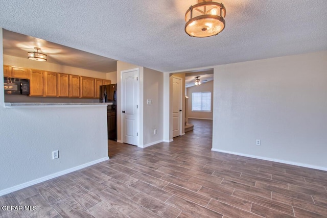 11924 Mesquite Rock Dr, El Paso, TX 79934 - unfurnished living room with a textured ceiling, wood finished floors, ceiling fan, and baseboards