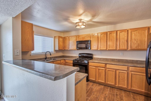 11924 Mesquite Rock Dr, El Paso, TX 79934 - kitchen featuring black appliances, a sink, a peninsula, a textured ceiling, and dark countertops