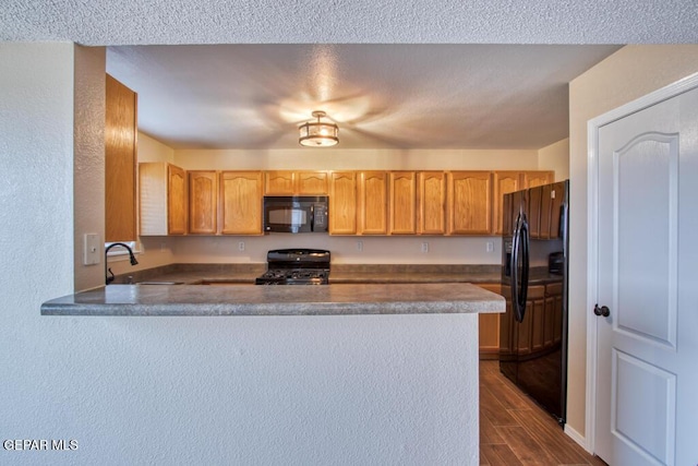 11924 Mesquite Rock Dr, El Paso, TX 79934 - kitchen with black appliances, a sink, a peninsula, dark wood-type flooring, and dark countertops