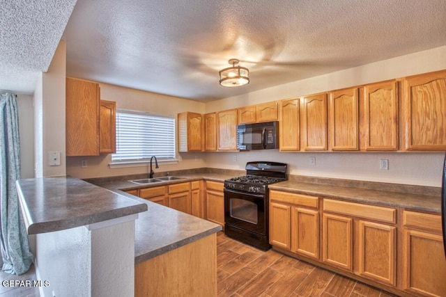 11924 Mesquite Rock Dr, El Paso, TX 79934 - kitchen with black appliances, a sink, a peninsula, dark countertops, and a textured ceiling