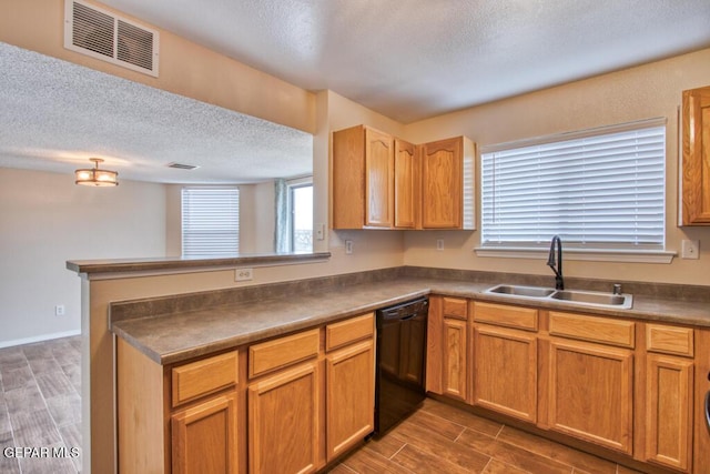 11924 Mesquite Rock Dr, El Paso, TX 79934 - kitchen with black dishwasher, a sink, a textured ceiling, dark countertops, and dark wood finished floors
