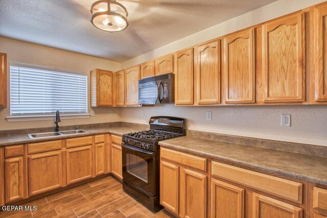 11924 Mesquite Rock Dr, El Paso, TX 79934 - kitchen featuring black appliances, a sink, dark wood-style floors, and dark countertops