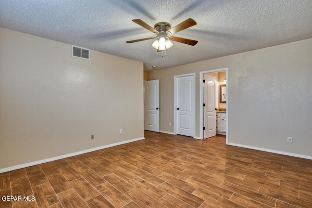 11924 Mesquite Rock Dr, El Paso, TX 79934 - unfurnished bedroom with wood finished floors, baseboards, ensuite bathroom, a textured ceiling, and ceiling fan