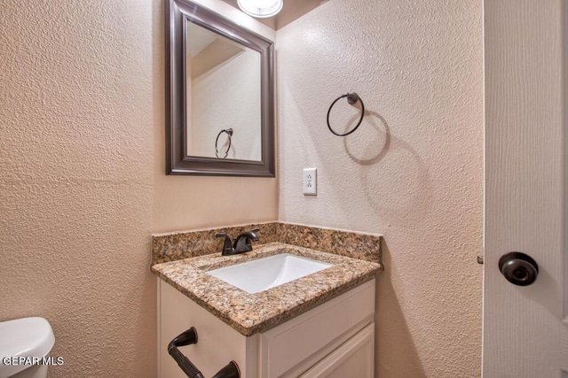 11924 Mesquite Rock Dr, El Paso, TX 79934 - bathroom featuring a textured wall, vanity, and toilet