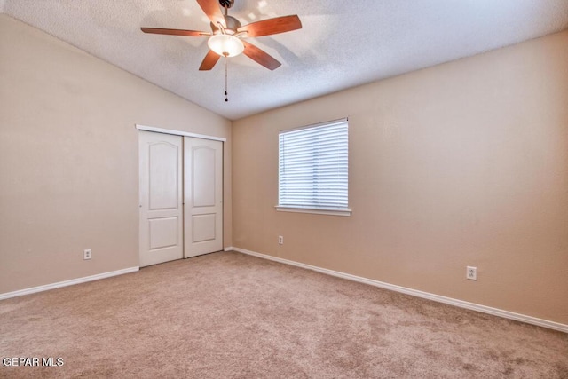 11924 Mesquite Rock Dr, El Paso, TX 79934 - unfurnished bedroom featuring carpet, baseboards, a textured ceiling, and vaulted ceiling