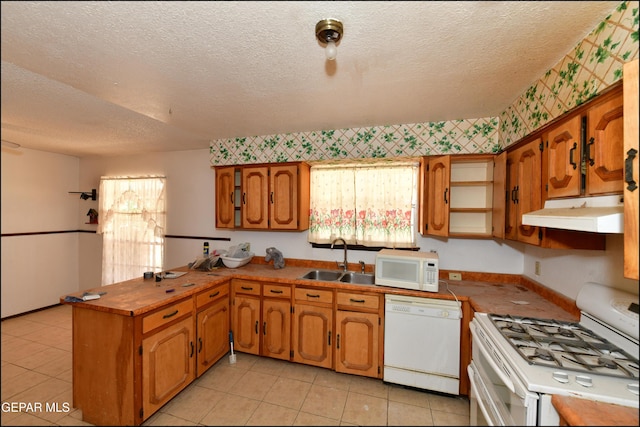 312 Caporal Ct, El Paso, TX 79932 - kitchen with white appliances, under cabinet range hood, a peninsula, a textured ceiling, and a sink