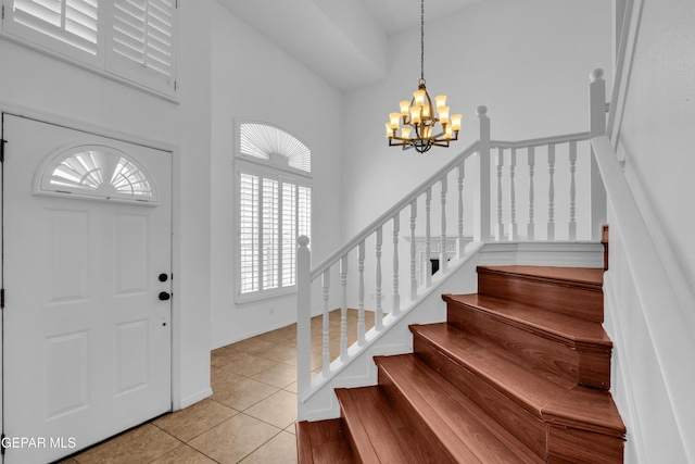 7461 Plaza Redonda Dr, El Paso, TX 79912 - entryway featuring a chandelier, plenty of natural light, light tile patterned flooring, stairway, and a high ceiling