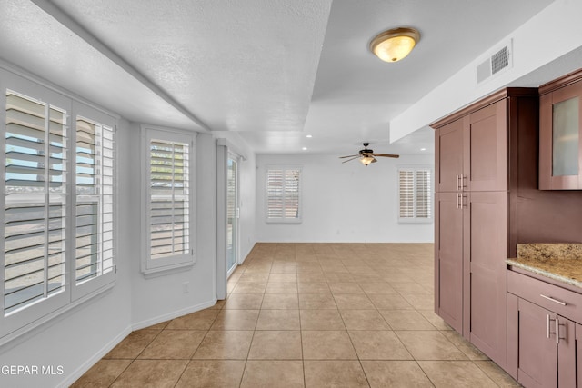 7461 Plaza Redonda Dr, El Paso, TX 79912 - interior space with a ceiling fan, light tile patterned floors, light stone counters, glass insert cabinets, and recessed lighting