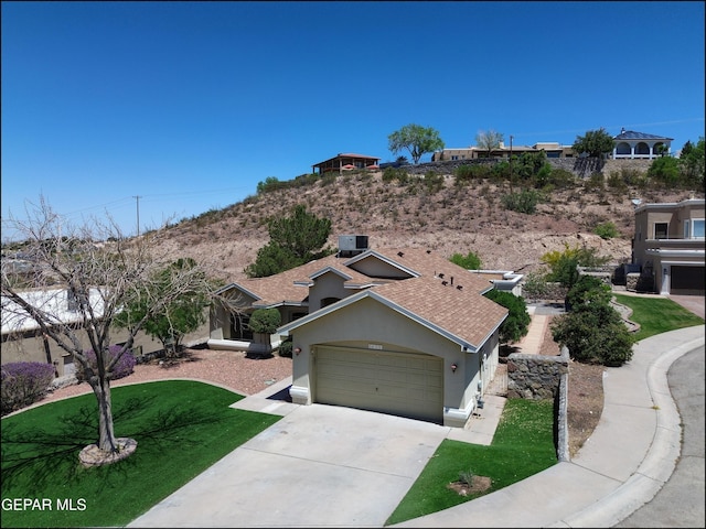 6609 El Poste Ct, El Paso, TX 79912 - view of front of property with stucco siding, an attached garage, driveway, and a front lawn