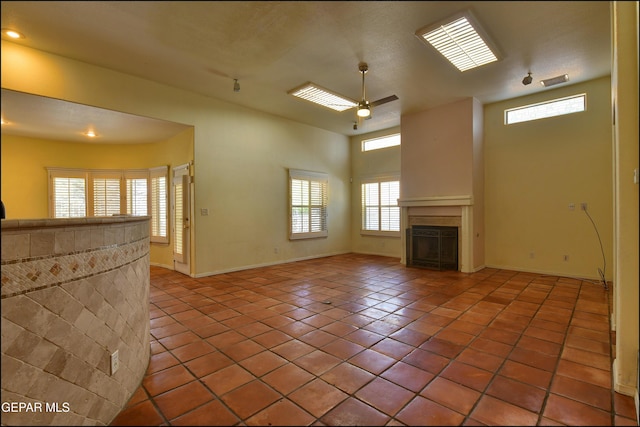 6609 El Poste Ct, El Paso, TX 79912 - unfurnished living room featuring ceiling fan, plenty of natural light, tile patterned flooring, and a fireplace