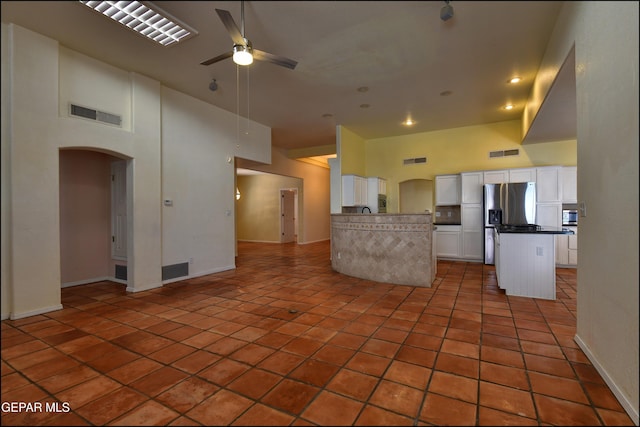 6609 El Poste Ct, El Paso, TX 79912 - kitchen featuring open floor plan, arched walkways, a ceiling fan, a towering ceiling, and stainless steel fridge with ice dispenser