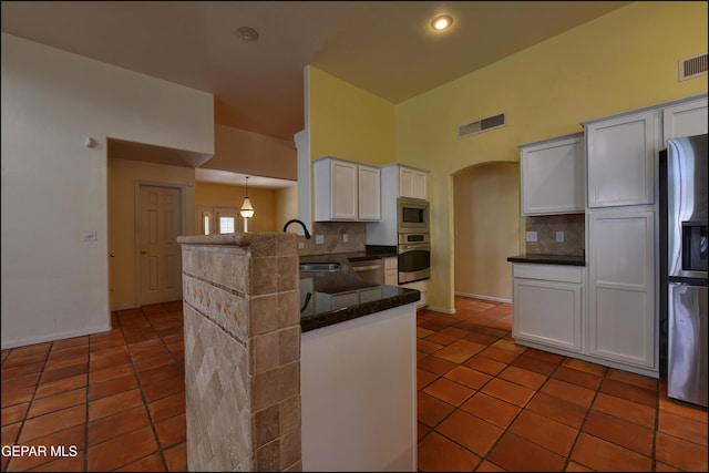 6609 El Poste Ct, El Paso, TX 79912 - kitchen with stainless steel appliances, a sink, a peninsula, tile patterned floors, and backsplash