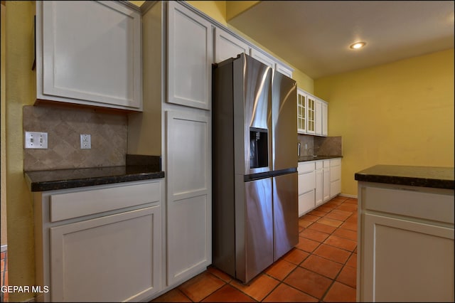 6609 El Poste Ct, El Paso, TX 79912 - kitchen with stainless steel refrigerator with ice dispenser, backsplash, light tile patterned floors, white cabinetry, and glass insert cabinets