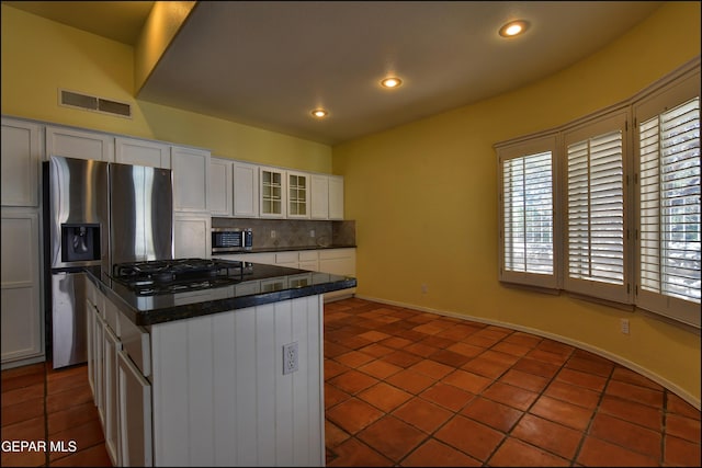 6609 El Poste Ct, El Paso, TX 79912 - kitchen with dark countertops, appliances with stainless steel finishes, decorative backsplash, tile patterned floors, and recessed lighting