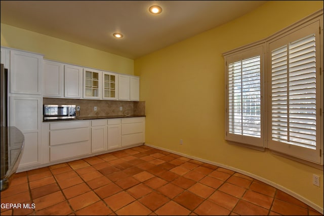6609 El Poste Ct, El Paso, TX 79912 - kitchen featuring stainless steel microwave, tasteful backsplash, dark countertops, white cabinets, and recessed lighting