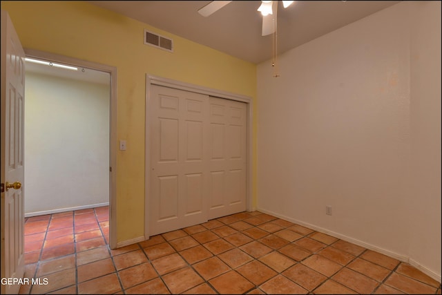 6609 El Poste Ct, El Paso, TX 79912 - unfurnished bedroom featuring a closet, light tile patterned floors, a ceiling fan, and baseboards