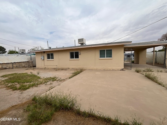 8244 Strickland Dr, El Paso, TX 79907 - back of property with stucco siding, central air condition unit, and a carport