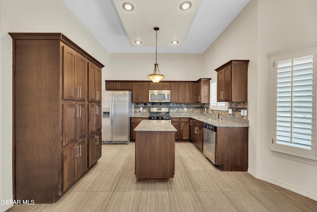 3199 Red Maple Dr, El Paso, TX 79938 - kitchen featuring appliances with stainless steel finishes, decorative backsplash, a center island, light stone countertops, and recessed lighting