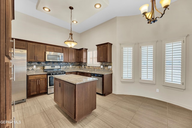 3199 Red Maple Dr, El Paso, TX 79938 - kitchen with stainless steel appliances, decorative backsplash, a sink, a towering ceiling, and light stone countertops