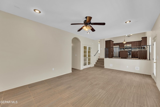 3199 Red Maple Dr, El Paso, TX 79938 - unfurnished living room with arched walkways, stairs, a ceiling fan, recessed lighting, and baseboards