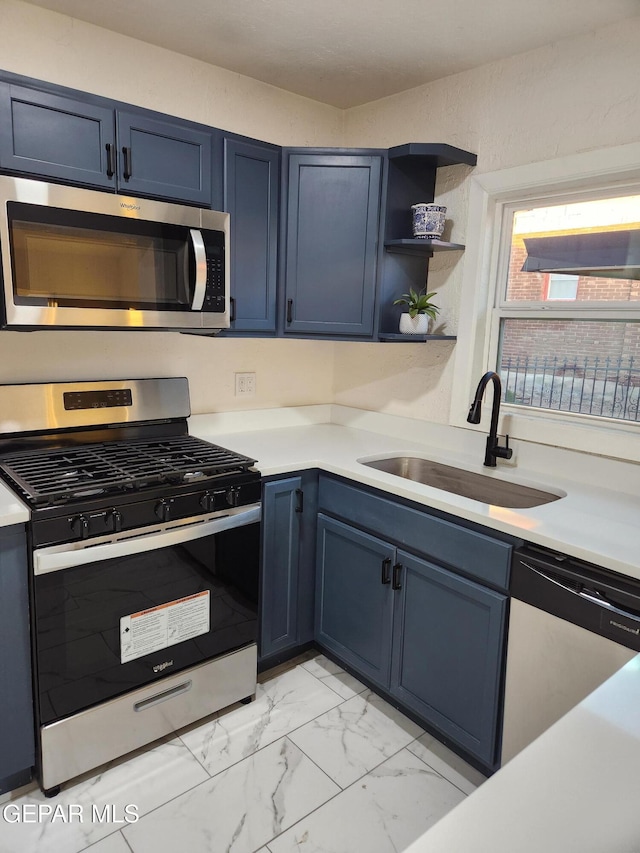 4122 Cumberland Ave, El Paso, TX 79903 - kitchen with stainless steel appliances, a sink, blue cabinetry, and light countertops