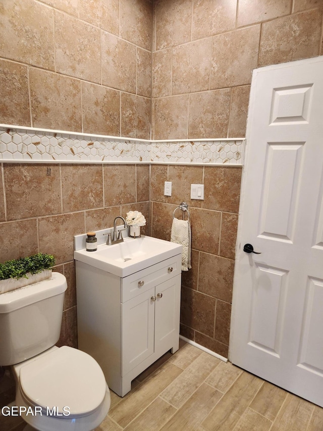 4122 Cumberland Ave, El Paso, TX 79903 - bathroom with tile walls, toilet, wood finished floors, and vanity