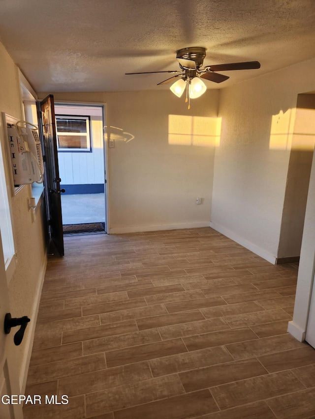 4122 Cumberland Ave, El Paso, TX 79903 - unfurnished room featuring a textured ceiling, a ceiling fan, wood finished floors, and baseboards