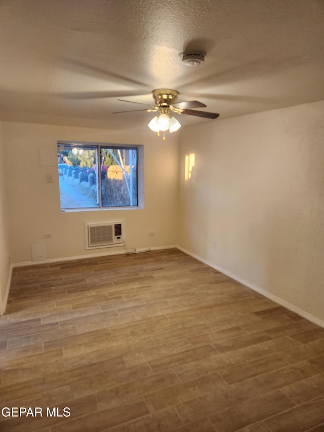 4122 Cumberland Ave, El Paso, TX 79903 - spare room featuring a ceiling fan, a wall mounted air conditioner, baseboards, a smoke detector, and wood finished floors