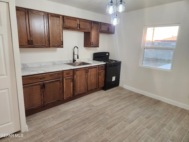 4122 Cumberland Ave, El Paso, TX 79903 - kitchen featuring gas stove, a sink, light wood-type flooring, and light countertops