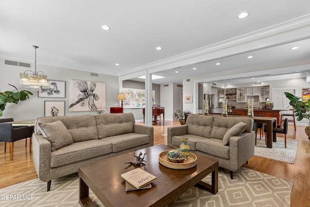 1119 Los Jardines Cir, El Paso, TX 79912 - living room featuring light wood finished floors, recessed lighting, crown molding, and a chandelier