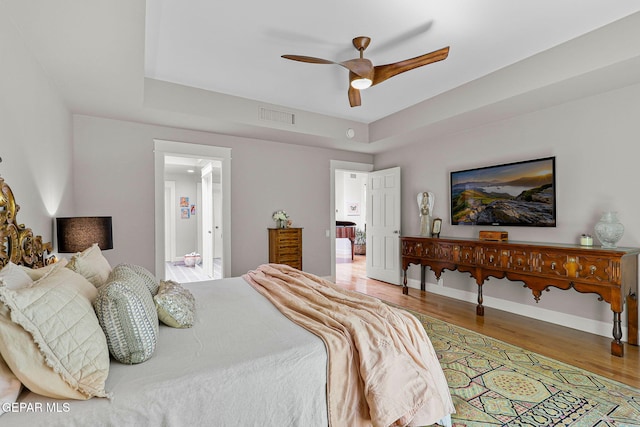 1119 Los Jardines Cir, El Paso, TX 79912 - bedroom with wood finished floors, a raised ceiling, a ceiling fan, and baseboards