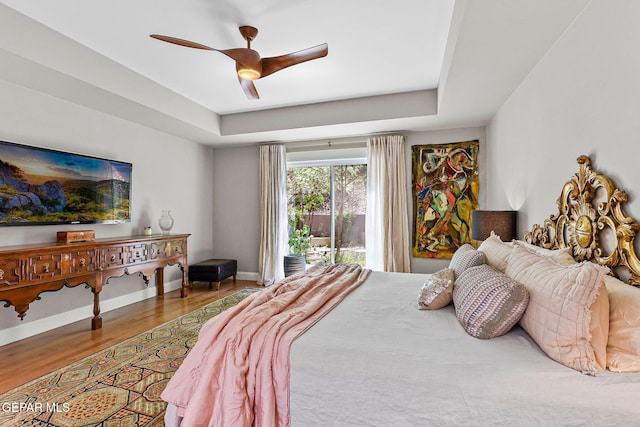 1119 Los Jardines Cir, El Paso, TX 79912 - bedroom with wood finished floors, a tray ceiling, baseboards, and a ceiling fan