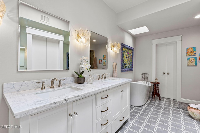 1119 Los Jardines Cir, El Paso, TX 79912 - full bath with a skylight, double vanity, a freestanding bath, tile patterned floors, and recessed lighting