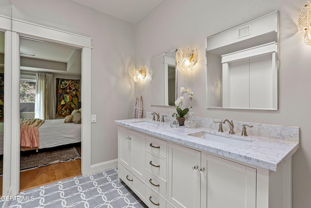 1119 Los Jardines Cir, El Paso, TX 79912 - bathroom featuring double vanity, ensuite bath, and baseboards