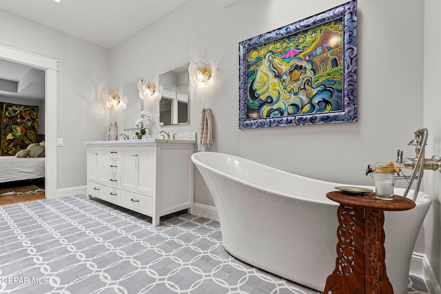 1119 Los Jardines Cir, El Paso, TX 79912 - bathroom with double vanity, a freestanding tub, baseboards, and ensuite bath