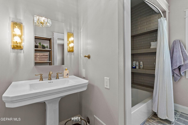1119 Los Jardines Cir, El Paso, TX 79912 - full bathroom with shower / bath combo with shower curtain, a sink, baseboards, and a chandelier