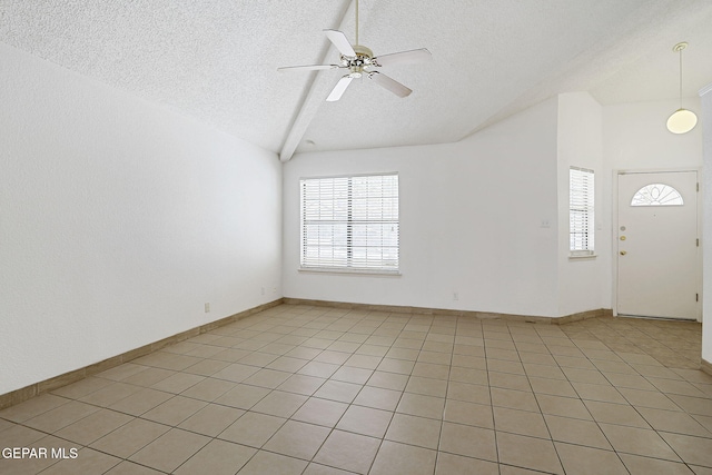 7145 Golden Hawk Dr, El Paso, TX 79912 - empty room with a textured ceiling, lofted ceiling, ceiling fan, light tile patterned flooring, and baseboards