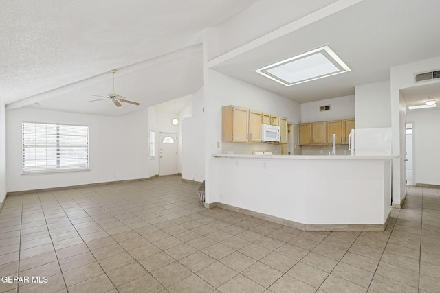 7145 Golden Hawk Dr, El Paso, TX 79912 - kitchen featuring white microwave, light brown cabinetry, open floor plan, light countertops, and light tile patterned floors