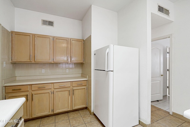 7145 Golden Hawk Dr, El Paso, TX 79912 - kitchen with freestanding refrigerator, tasteful backsplash, light brown cabinetry, and light countertops